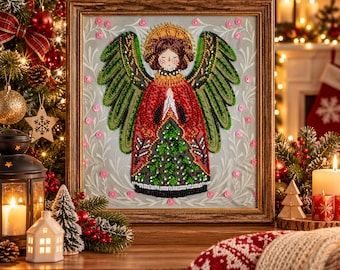 May include: A framed diamond painting art piece featuring a stylized angel with large green wings, a red robe with a green tree pattern, and a golden halo. The angel has hands pressed together in prayer and is surrounded by a light gray background.