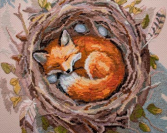 May include: A cross-stitch image of a sleeping fox curled up in a nest. The fox has orange fur with white accents and is nestled among brown twigs, leaves, and three blue eggs. A feather is visible on the right side.