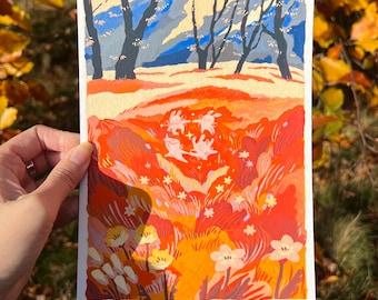 May include: A colorful painting of a landscape with trees and flowers. The artwork features a vibrant palette of orange, red, yellow, and blue hues. The painting is held by a person's hand, with a blurred background of autumn leaves.