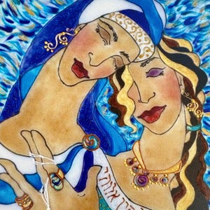 May include: A canvas painting depicting two figures with closed eyes, one wearing a blue head covering and the other with wavy brown hair. They are adorned with gold jewelry, including necklaces and rings. A white banner with Hebrew text is draped across.