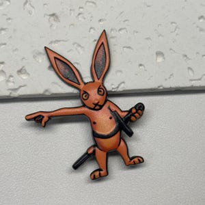 Puede incluir: Conejo de dibujos animados naranja con una espada, sosteniendo una espada en una mano y apuntando con la otra. El conejo tiene una expresi&oacute;n seria en su rostro.