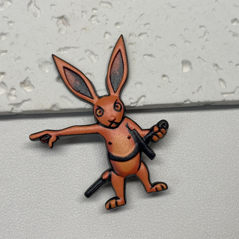 Puede incluir: Conejo de dibujos animados naranja con una espada, sosteniendo una espada en una mano y apuntando con la otra. El conejo tiene una expresi&oacute;n seria en su rostro.