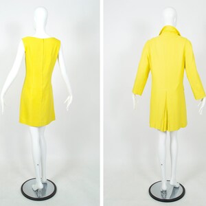 May include: A yellow sleeveless dress and a matching yellow coat. Both garments are made of a smooth, lightweight fabric.