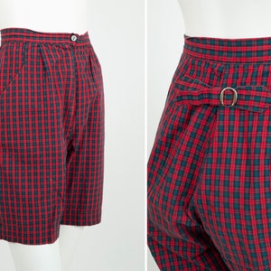 May include: Red and black plaid shorts with a belt loop and buckle on the back. The shorts have a high waist and are made of a lightweight fabric.