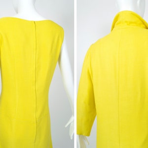 May include: Back view of a yellow sleeveless dress with a simple design. The dress has a straight cut and a back zipper.