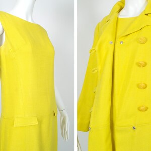 May include: A bright yellow sleeveless dress and matching coat with large buttons. The dress has a simple, straight cut and the coat has a double-breasted closure.