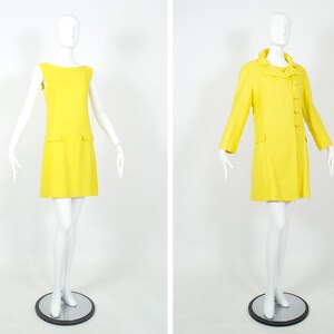 May include: Two mannequins wearing matching yellow sleeveless dresses and coats. The dress is a simple A-line style with a pocket on each side. The coat has a double-breasted closure and long sleeves.
