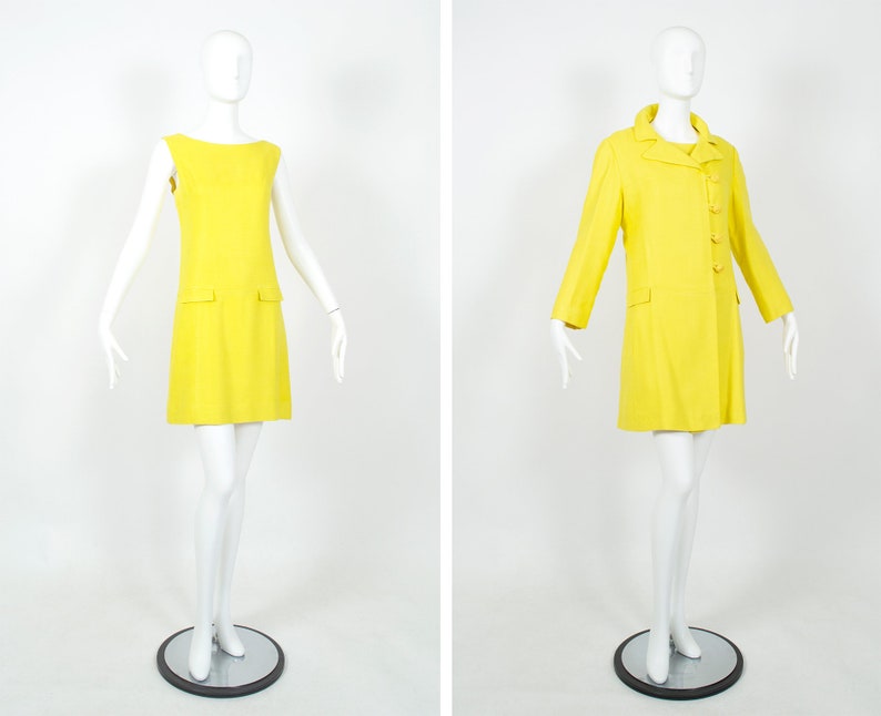 May include: Two mannequins wearing matching yellow sleeveless dresses and coats. The dress is a simple A-line style with a pocket on each side. The coat has a double-breasted closure and long sleeves.