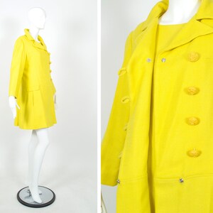 May include: A bright yellow coat and dress set with a double-breasted closure and four large yellow buttons. The coat has a long sleeve and a slightly flared skirt. The dress has a short sleeve and a straight skirt.