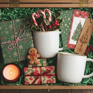 Op de afbeelding: Een houten kist gevuld met kerstartikelen. Inclusief ingepakte cadeaus, mokken, zuurstokken, labels, een peperkoeken man en een brandende kaars. De cadeaus zijn verpakt in groen papier met sneeuwvlokpatronen en vastgebonden met rood-wit touw.