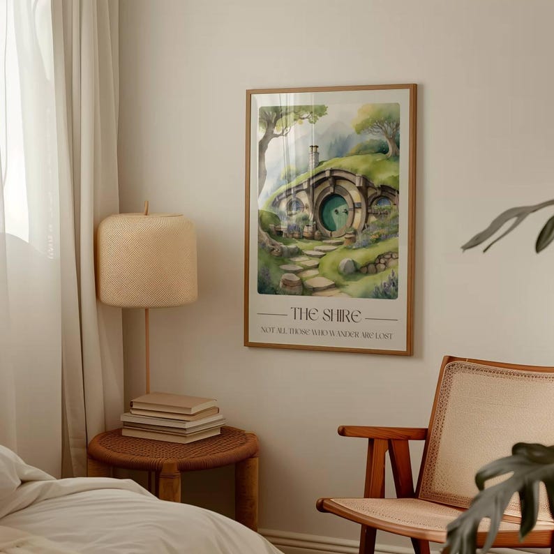 May include: A watercolor illustration of a hobbit hole in the Shire, with a green door and a winding path leading up to it. The text below reads "The Shire - Not all those who wander are lost."