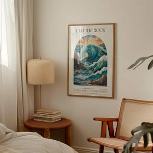 May include: A framed poster with a blue and green watercolor illustration of a wave crashing against a rocky shore. The text "I AM THE ROCK AGAINST WHICH THE SEA CRASHES" is printed below the image.