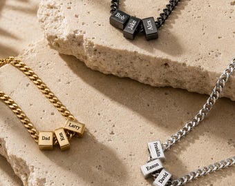 Può includere: Tre collane a catena gourmette in tonalità nero, oro e argento. Ogni collana presenta tre piccole perline rettangolari incise con dei nomi. Le perline nere riportano Bob, Jake e Alex. Quelle dorate riportano Dad, Ken e Larry. Quelle argentate riportano Franklin, Eason e David.