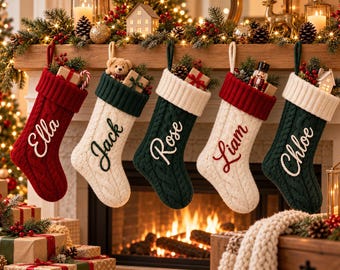 Könnte beinhalten: Fünf Weihnachtsstrümpfe aus Zopfstrick hängen in einer Reihe, mit den Namen Ella, Jack, Rose, Liam und Chloe auf den Bündchen. Die Strümpfe sind rot, weiß und dunkelgrün und mit kleinen Geschenken, Tannenzapfen und Tannengrün gefüllt.