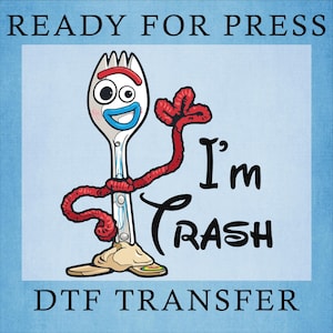 May include: A blue background with the text "READY FOR PRESS" at the top and "DTF TRANSFER" at the bottom. In the center is a cartoon image of a fork with a red yarn body and the text "I'm TRASH".
