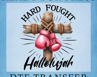 May include: A graphic design featuring a wooden cross wrapped in rope with a pair of pink boxing gloves hanging from the center. The text reads READY FOR PRESS, HARD FOUGHT, Hallelujah, and DTF TRANSFER in black lettering against a light blue background.