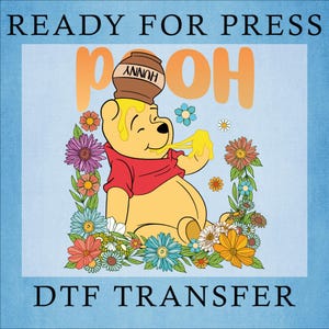 May include: A DTF transfer featuring a yellow bear wearing a red shirt with a brown honey pot labeled HUNNY on its head. The bear is surrounded by colorful flowers on a light blue background with the text READY FOR PRESS and DTF TRANSFER.