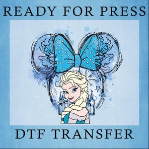 May include: A blue and white DTF transfer design featuring a cartoon image of Elsa from Frozen wearing a blue bow with white polka dots. The design includes a watercolor background with a castle and stars.