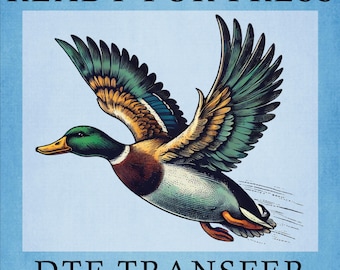 May include: A colorful illustration of a flying duck with green, blue, orange, and brown feathers. The duck is in mid-flight against a light blue background. The text "READY FOR PRESS" and "DTF TRANSFER" are at the top and bottom.