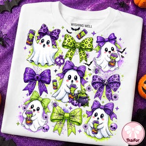 May include: A white t-shirt featuring a graphic print of five white ghosts with large eyes, each wearing a purple or green patterned bow. The design includes purple and green bows, small bats, spiders, skulls, and cans with green liquid.