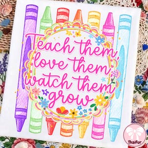 May include: A white fabric surface featuring a colorful graphic of vertical crayons in purple, green, red, orange, yellow, pink, and blue. Centered is a scalloped circular frame with the pink text: Teach them, love them, watch them grow.