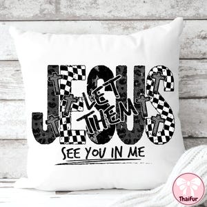 May include: White decorative pillow with the words "JESUS LET THEM SEE YOU IN ME" in black. The word "JESUS" is in a checkered pattern, and the word "THEM" is in a leopard print. Small crosses are incorporated into the design.