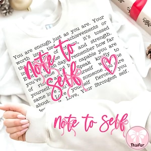 May include: White sweatshirt with the text "Note to Self" in pink script. The sweatshirt has a printed message in black font. The design includes pink bows and a heart. The brand name "ThaiFur" is in the bottom right corner.