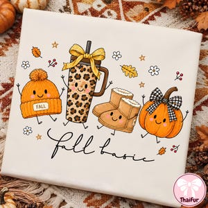 May include: A white t-shirt featuring a graphic print of a smiling orange beanie with a tag reading FALL, a leopard print tumbler with a yellow bow, tan boots, and an orange pumpkin with a black and white plaid bow, with the text fall basic.