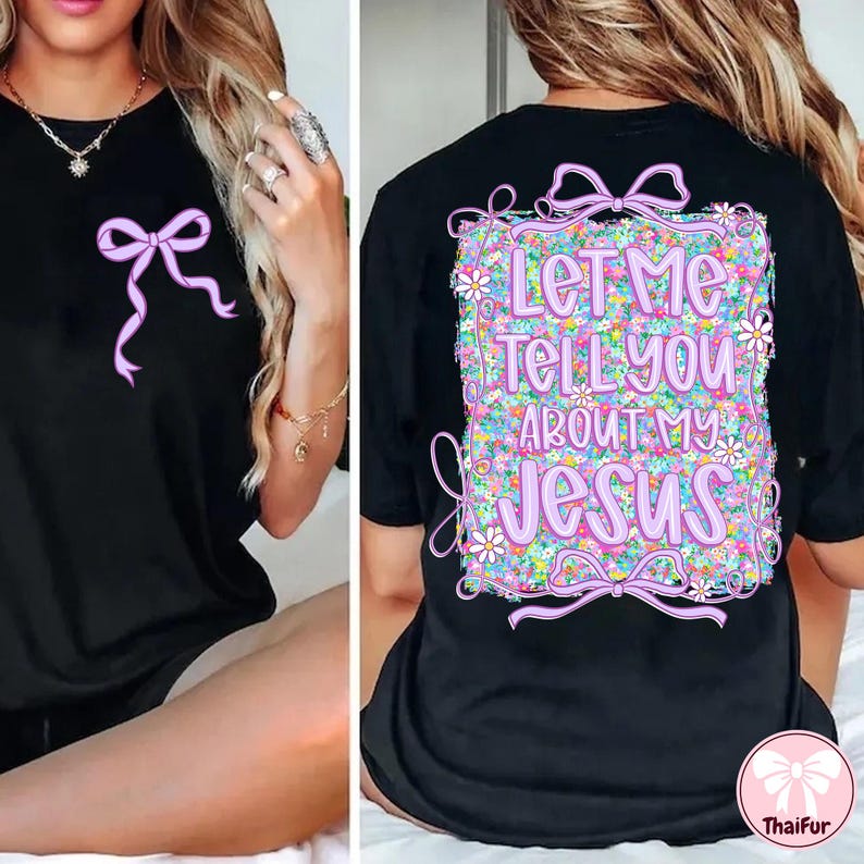 Puede incluir: Camiseta negra con un dise&ntilde;o floral y el texto "Let me tell you about my Jesus" en rosa. Un lazo rosa est&aacute; en la parte delantera de la camiseta.