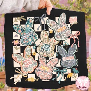 Peut inclure: Design de Pâques carré noir avec six lapins floraux et du texte. Les lapins présentent des phrases telles que "Worthy", "Risen", "True Story", "Three Days", "Faith" et "Strong". Le fond est un motif à carreaux noir et blanc.