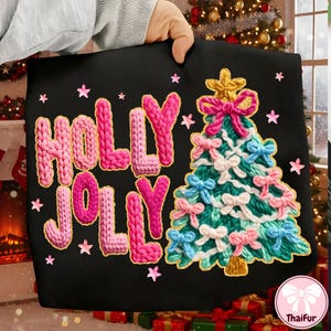 May include: Black tote bag with the words "HOLLY JOLLY" in pink and gold knitted letters. A knitted Christmas tree with pink, blue, and white bows is on the right. Pink stars are scattered around the design.