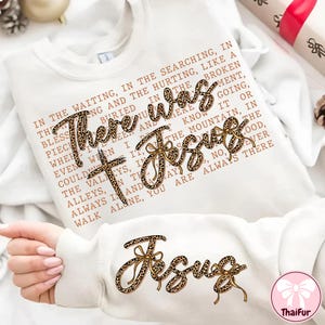 May include: White sweatshirt with the text "There was Jesus" in a leopard print design. The sweatshirt also features a cross and additional text in a brown font. The design is repeated on the sleeve.