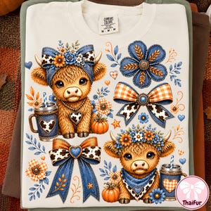 May include: A cream-colored t-shirt featuring a graphic print of two fluffy brown highland calves, each wearing a floral crown and a bandana. The design includes blue and orange plaid bows, pumpkins, and mugs with heart patterns, all in a rustic style.