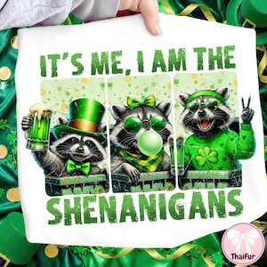 Pode incluir: Camiseta branca com um design do Dia de São Patrício. Apresenta três guaxinins em trajes verdes, incluindo chapéus e óculos de sol. O texto "IT'S ME, I AM THE SHENANIGANS" é impresso em verde. Os guaxinins seguram cerveja.