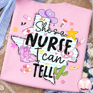Può includere: Una t-shirt rosa chiaro con una grafica dello stato del Texas con linee orizzontali blu. Il testo recita "She's a NURSE I can TELL". Le grafiche includono un cappello da cowboy viola, stivali rosa, uno stetoscopio, una siringa e un cactus.