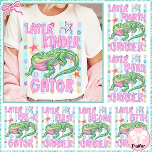 Peut inclure: T-shirt blanc avec un motif coloré représentant un alligator vert et les mots "Later Kinder Gator" en rose. Le motif comprend des étoiles et des fleurs. Des cartes supplémentaires montrent l'alligator avec les niveaux scolaires.