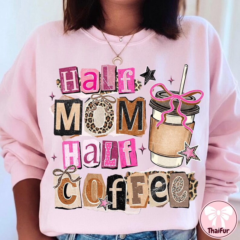 May include: Pink sweatshirt with the text "Half Mom Half Coffee" in a collage style. The design includes a coffee cup with a pink bow and star accents. The sweatshirt is a light pink color.