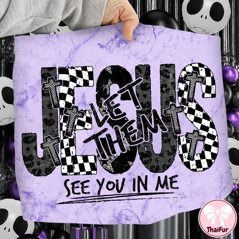 May include: A purple and white graphic with the words "JESUS LET THEM SEE YOU IN ME". The word "JESUS" is in a black checkered pattern, and the words "LET THEM" are in a black leopard print. Small crosses are placed throughout the design.