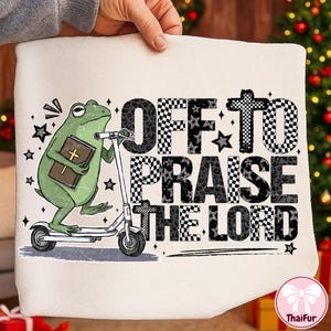 May include: Off-white fabric featuring a green frog on a scooter, holding a book with a cross. The text "OFF TO PRAISE THE LORD" is in black and checkered patterns, with star accents.