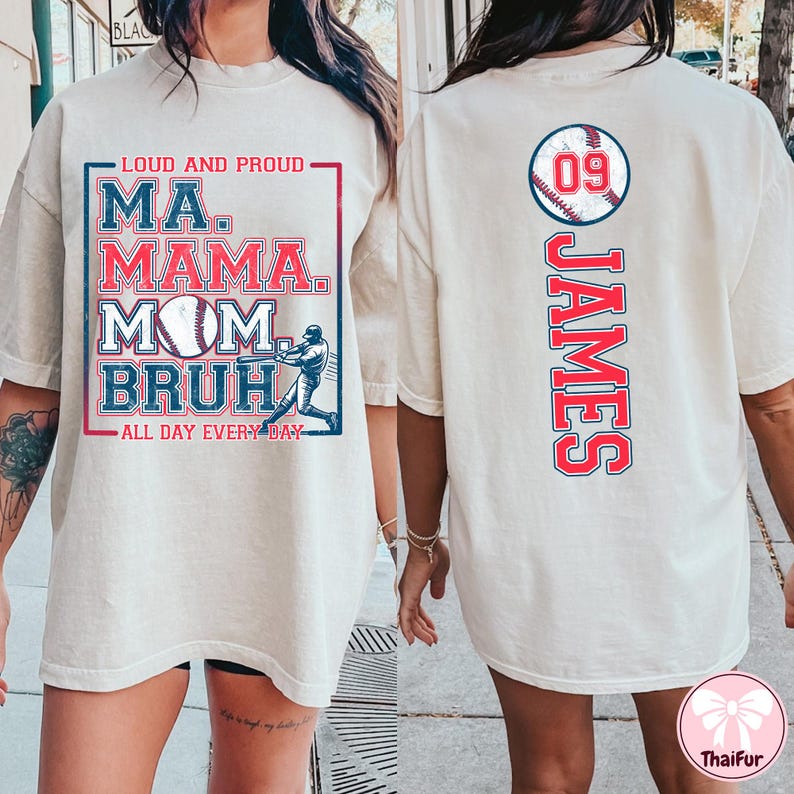 May include: White t-shirt with a baseball theme. The front of the shirt has the text "Loud and Proud" and "Ma. Mama. Mom.  Bruh." with a baseball and a baseball player graphic. The back of the shirt has the number "09" and the name "James" in red with a baseball graphic.