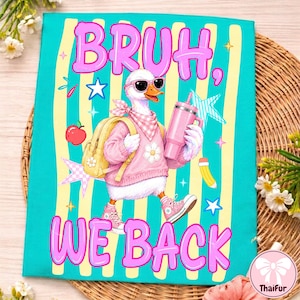 May include: A teal t-shirt featuring a graphic of a white duck wearing pink sunglasses, a pink sweater, a checkered scarf, and a yellow backpack. The duck holds a pink tumbler. The text reads BRUH, WE BACK in pink letters, surrounded by stars, an apple, and a pencil.