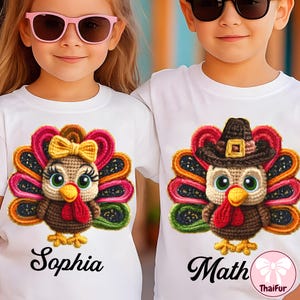May include: Two children wearing white t-shirts with crochet turkey designs. One turkey has a yellow bow, the other a pilgrim hat. The names "Sophia" and "Math" are printed below the turkeys. Both children are wearing sunglasses.