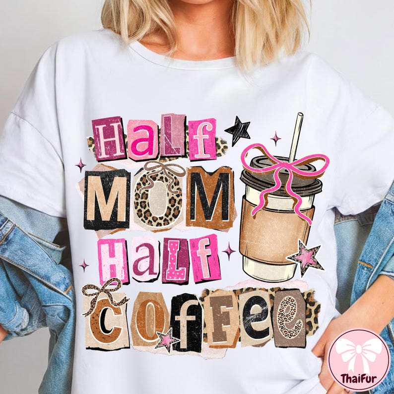 May include: White t-shirt with the text "Half Mom Half Coffee" in pink, brown, and black letters. The design includes a coffee cup with a pink bow and star accents. The shirt has a casual, everyday style.