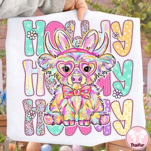 May include: White t-shirt featuring a colorful illustration of a dog with bunny ears, heart-shaped glasses, and a bow tie. The text "HOLLY HOLLY HOLLY" is displayed in various colors and patterns, with floral accents.