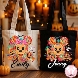 May include: Two Halloween-themed tote bags. One is beige, the other black. Each features a cartoon character with Mickey Mouse ears, surrounded by pumpkins, bats, and ghosts. The beige bag has the name "Emily" and the black bag has the name "Jonny".