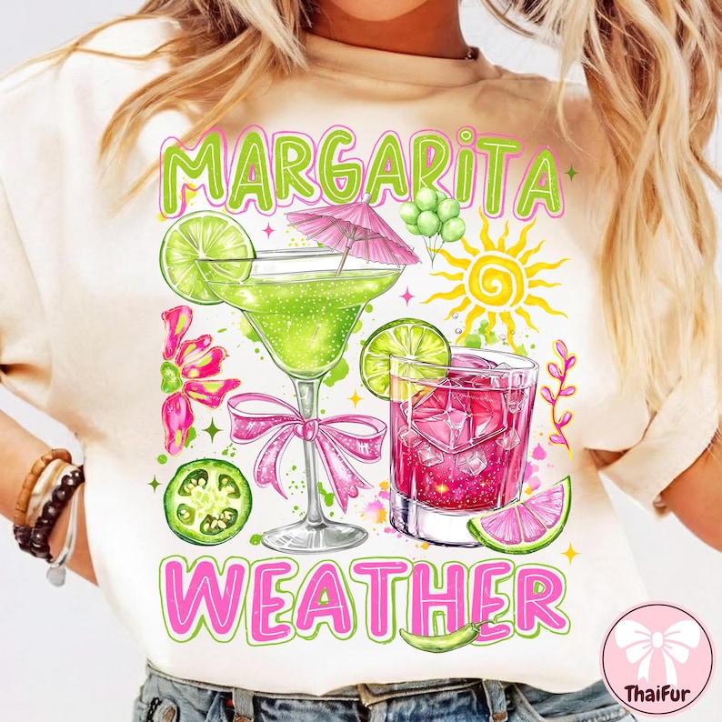 May include: A cream-coloured t-shirt with a vibrant graphic of two cocktails, a margarita and a pink drink, with lime slices and a sun. The text "Margarita Weather" is displayed in green and pink.
