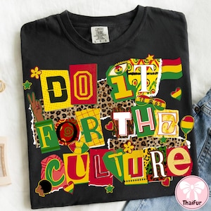以下が含まれることがあります： カラフルなブロックレターで「DO IT FOR THE CULTURE」と書かれた黒いTシャツ。デザインには、ヒョウ柄の背景、平和のサイン、赤、黄、緑の様々なグラフィック要素が含まれています。