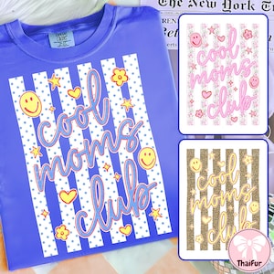 May include: A periwinkle blue t-shirt with the words "cool moms club" in a script font. The design includes white vertical stripes, yellow stars, hearts, flowers, and smiley faces. Additional designs are shown on the right.