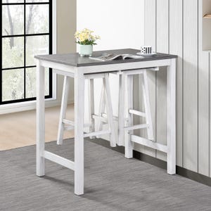 May include: White counter height table with a gray top and two white stools. The table and stools are made of wood and have a distressed finish.