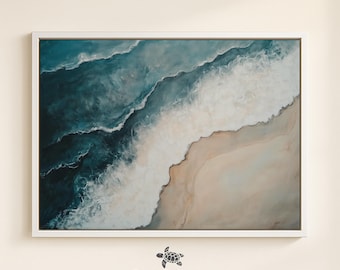 May include: A framed artwork depicting an aerial view of a beach scene. The painting features shades of blue and white to represent the ocean waves, which crash onto a sandy shore. The artwork is framed in a white border, and the text "BLUE COASTAL COLLECTIVE" is at the bottom.